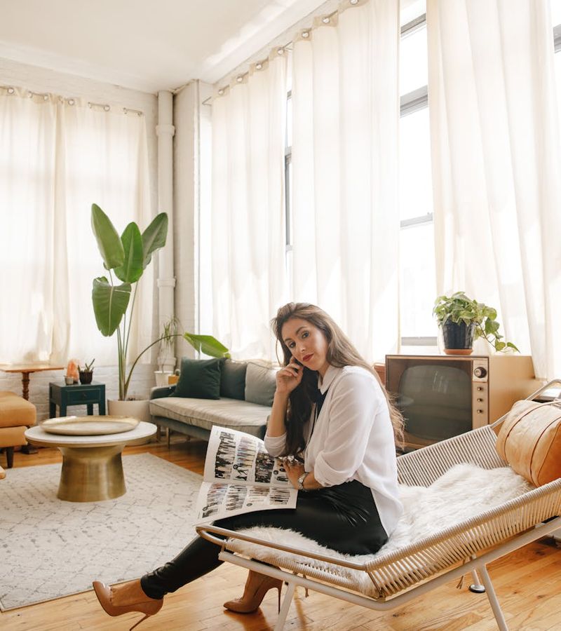 Person mid-stretch in a brightly lit room with minimalist decor, creating a sense of calm.