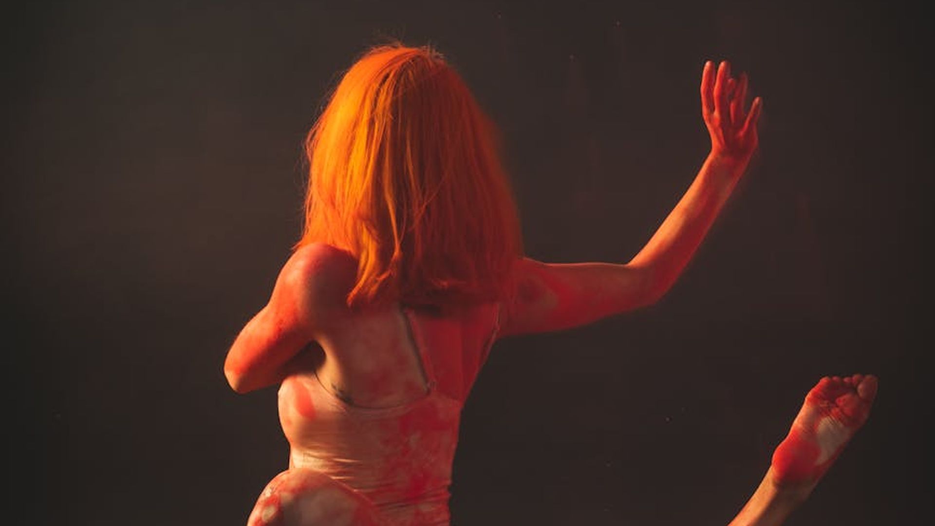 Silhouette of a person in a balanced yoga pose against a calm, dark background.