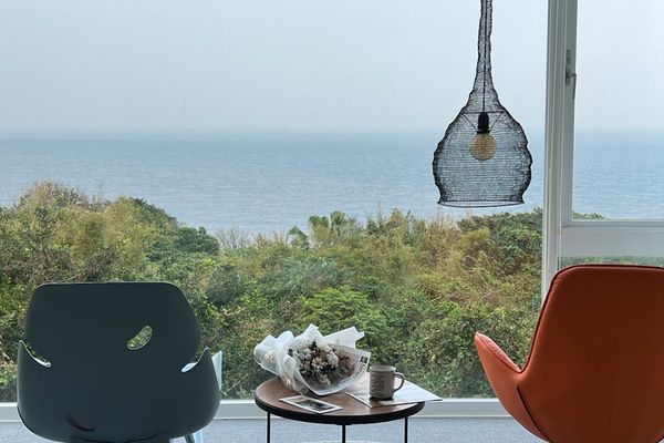 View of a tranquil natural landscape from a window next to a yoga space.